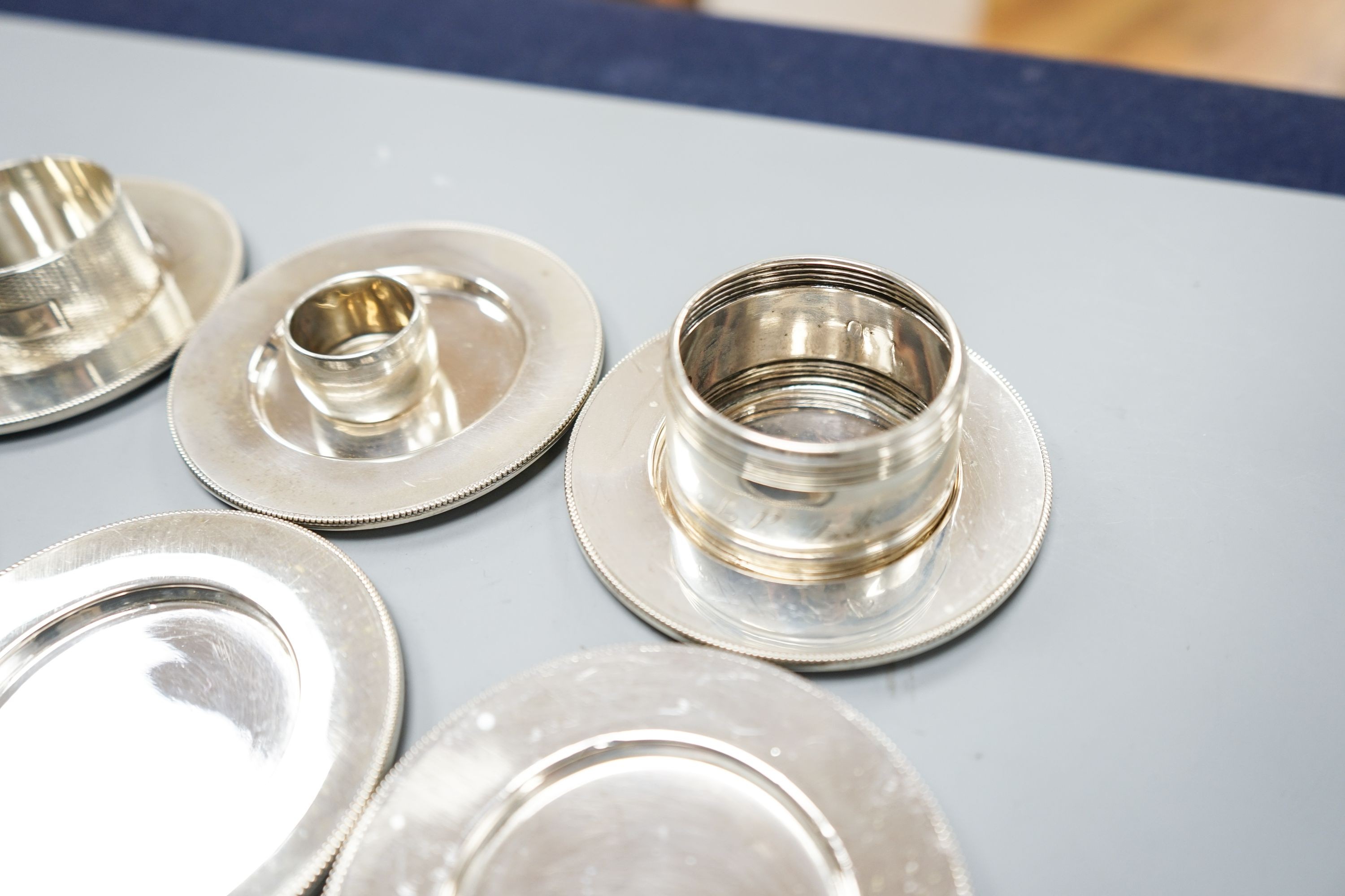 Six 830 standard white metal coasters and three napkin rings